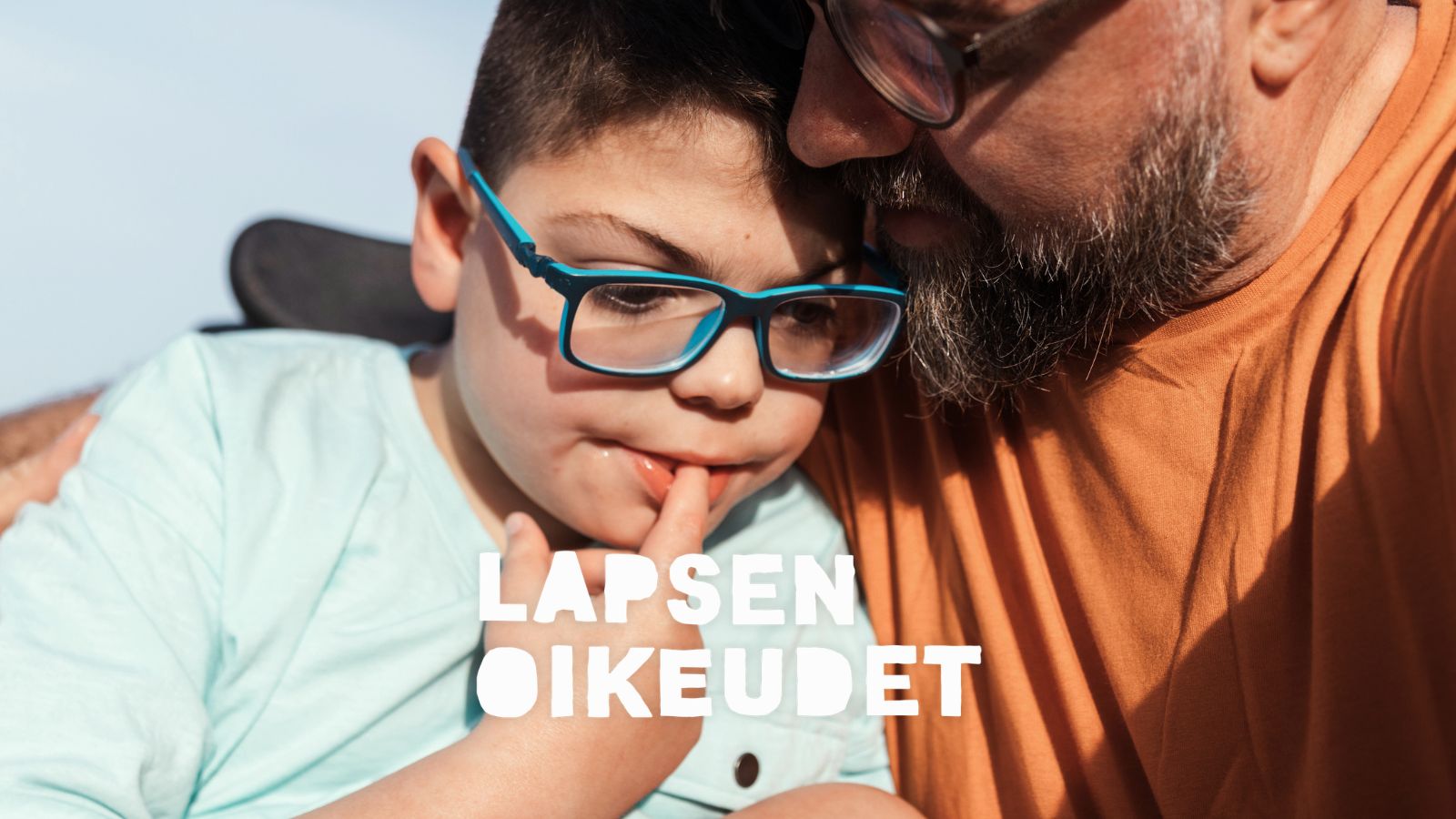 Vammainen lapsi on isän kainalossa.