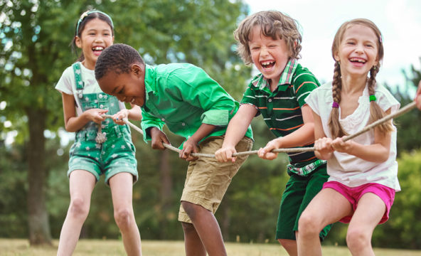 A group of children is pulling a rope together on the same side.