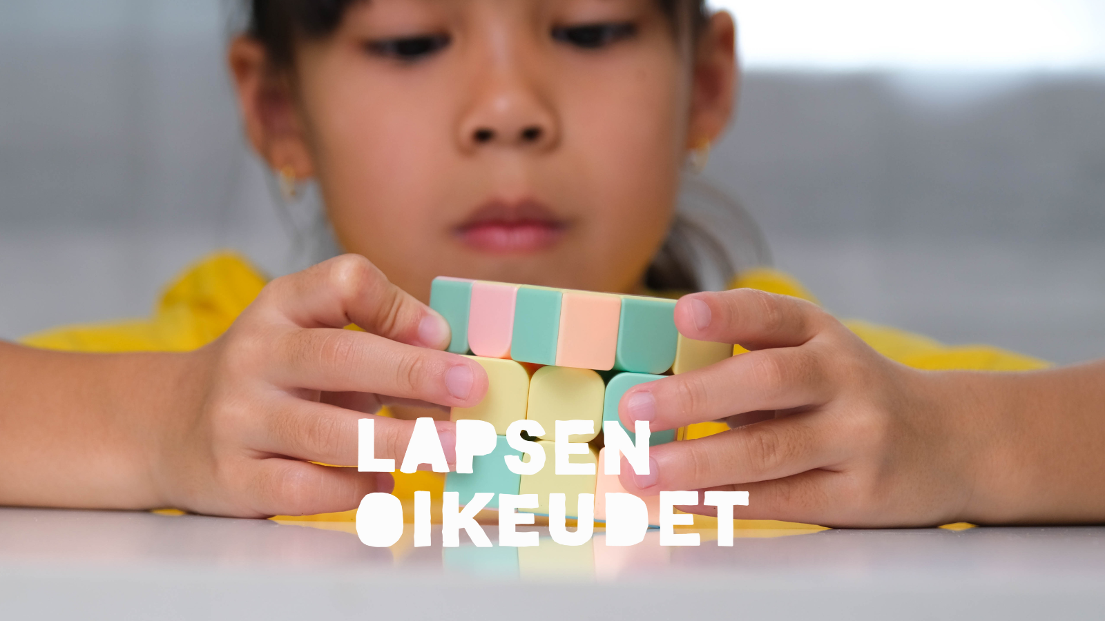 Lapsi leikkii kuutiolla.