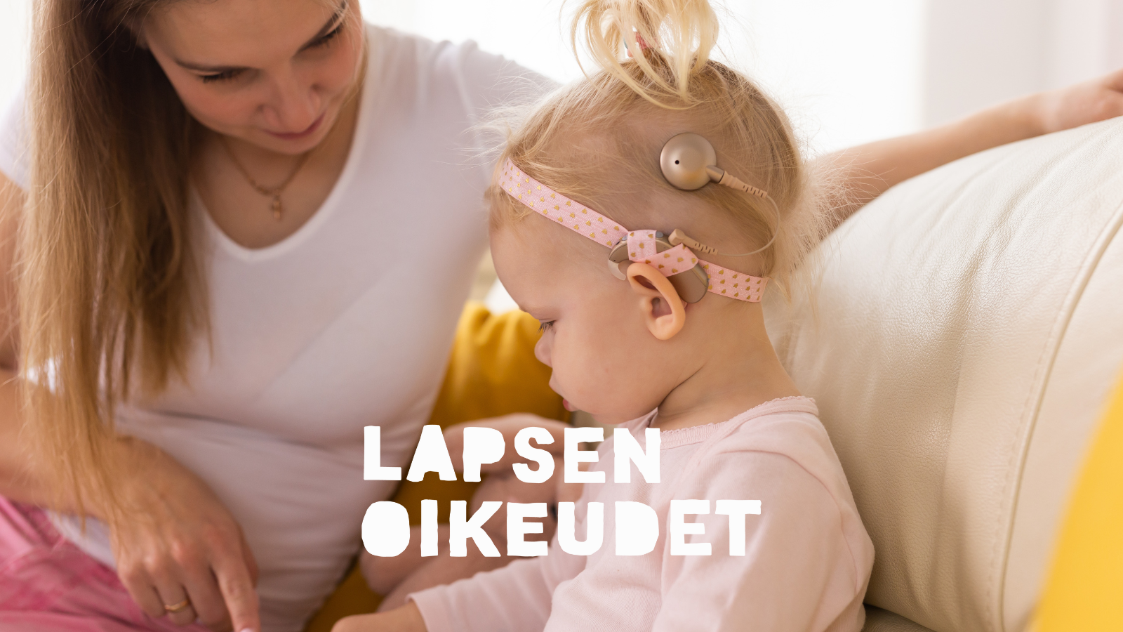 Kuulovammainen lapsi leikkii aikuisen kanssa.