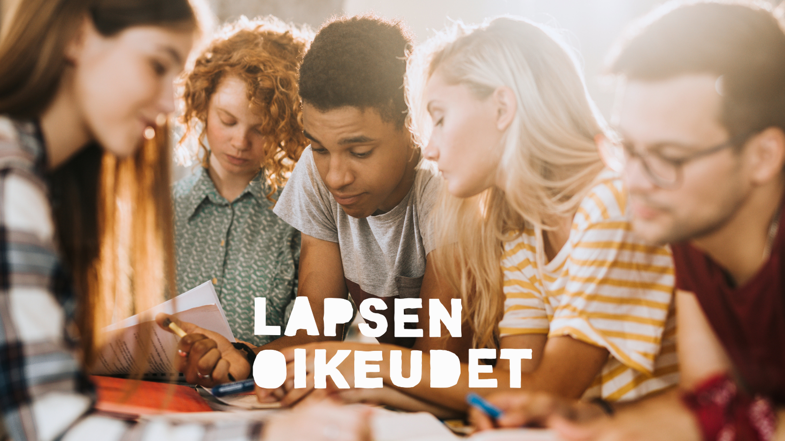 Nuorisojoukko pöydän ääressä työskentelemässä.