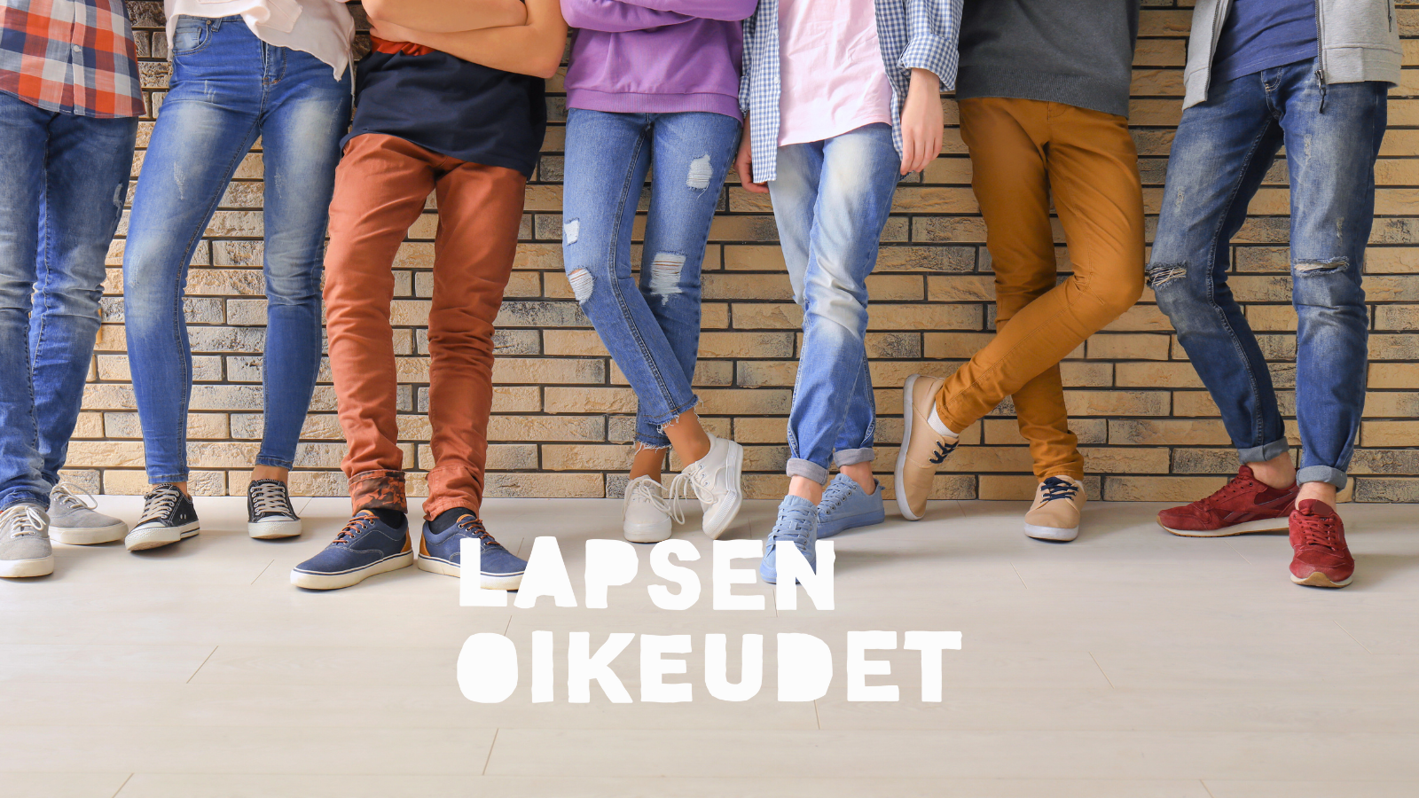 Nuoret nojailevat tiiliseinään.